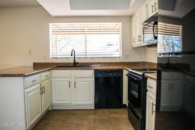 a kitchen with granite countertop a sink stove and cabinets