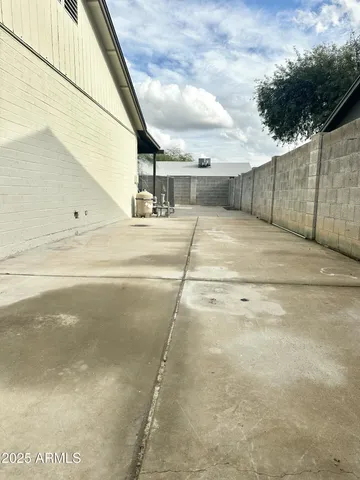 a patio with table and chairs and potted plants