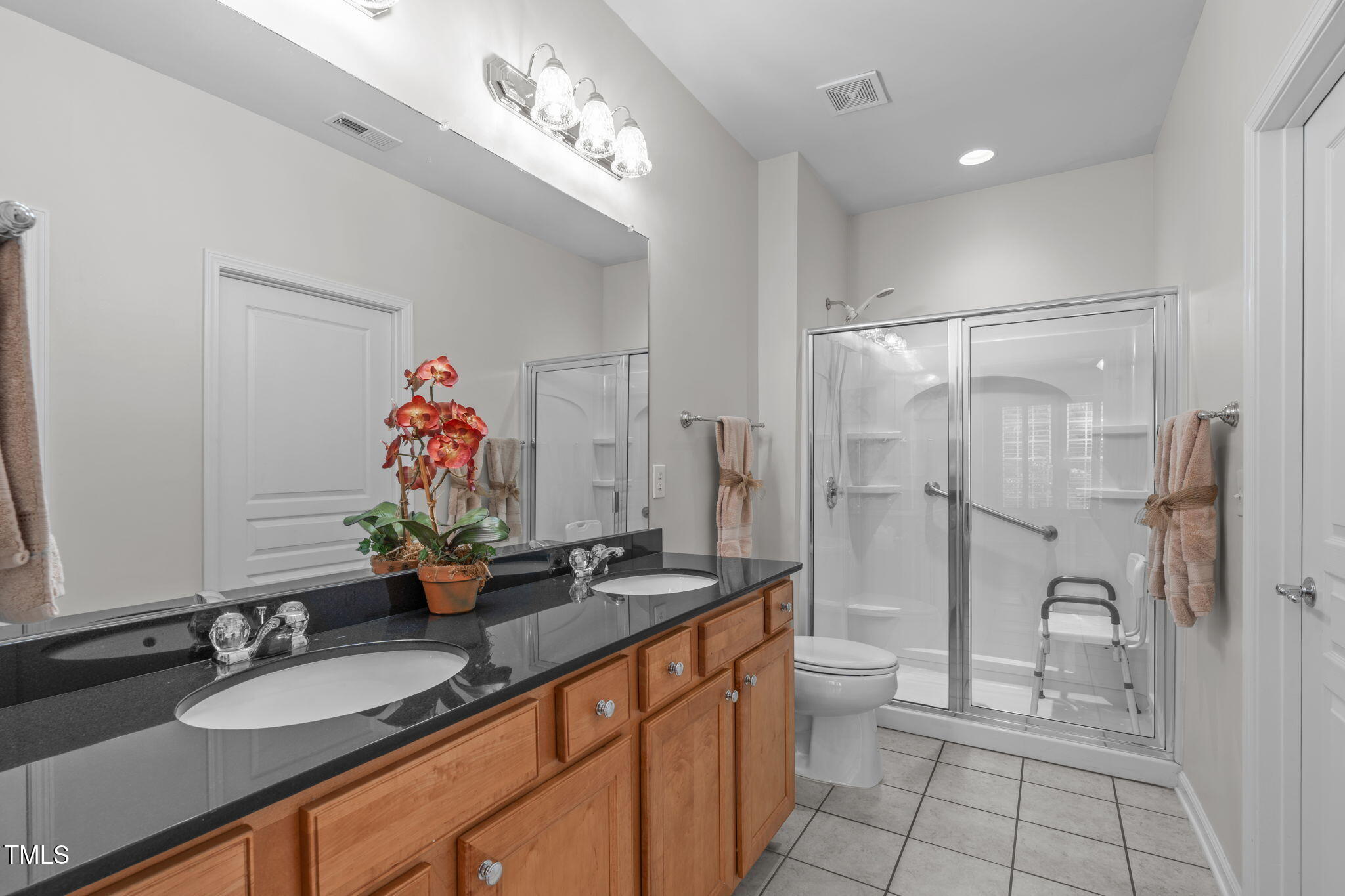 128 Arvind Oaks Circle Cary, NC 27519 - Photo 23 of 34 a bathroom with a granite countertop sink a toilet a mirror and shower