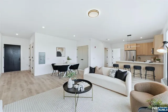 a living room with furniture and a view of kitchen