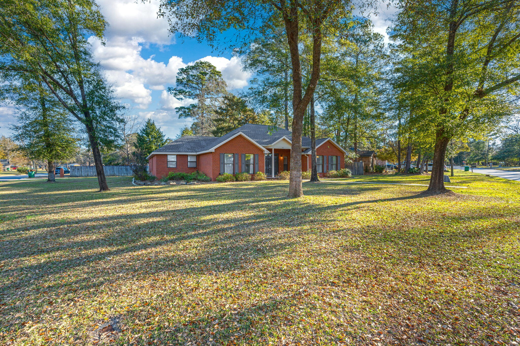 a view of big house with a garden and trees