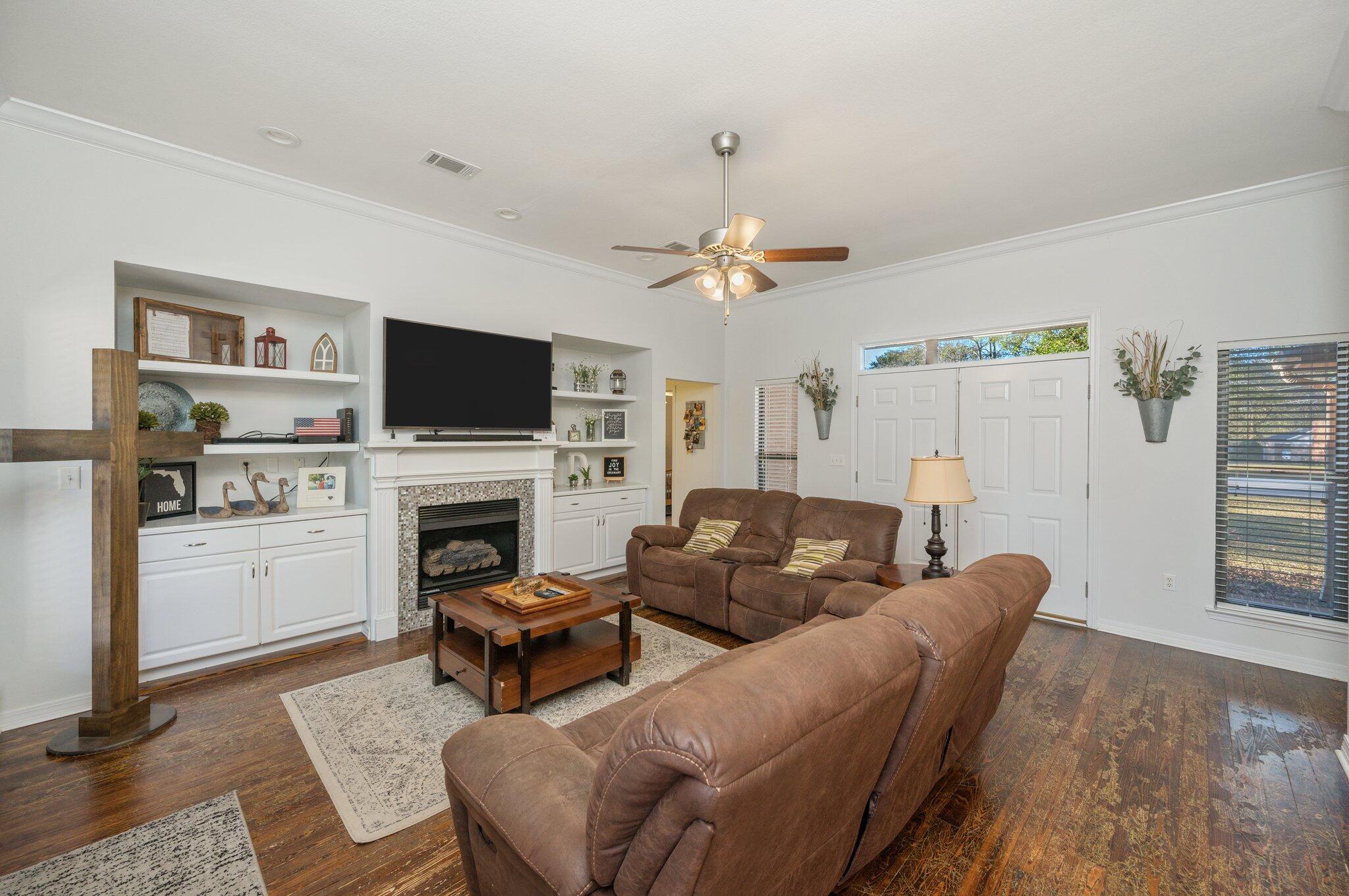 191 Adams Drive Crestview, FL 32536 - Photo 5 of 29 a living room with furniture a fireplace and a flat screen tv