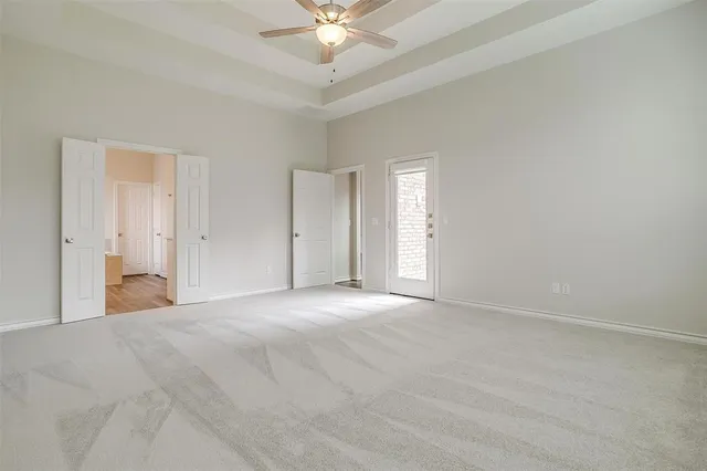 a view of an empty room with a chandelier fan