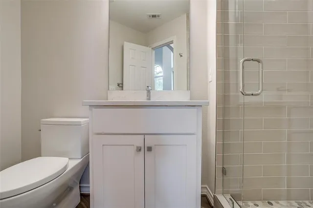 a bathroom with a toilet a sink and mirror