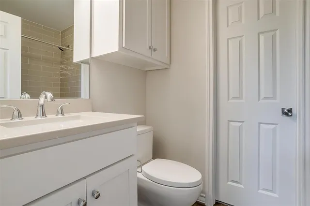 a bathroom with a sink a toilet and a mirror