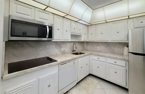 a kitchen with stainless steel appliances granite countertop white cabinets sink and dishwasher