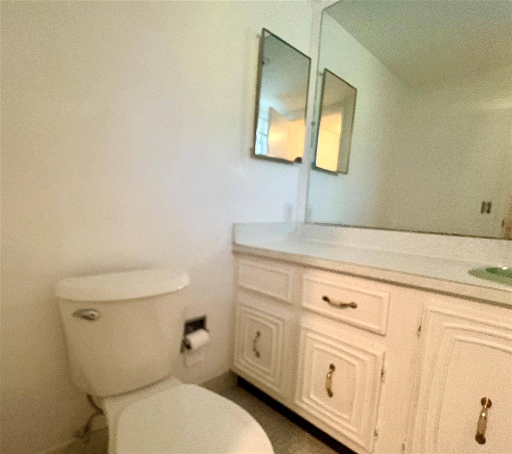 2601 South Course Drive, Unit 406 Pompano Beach, FL 33069 - Photo 12 of 15 a bathroom with a toilet sink and mirror