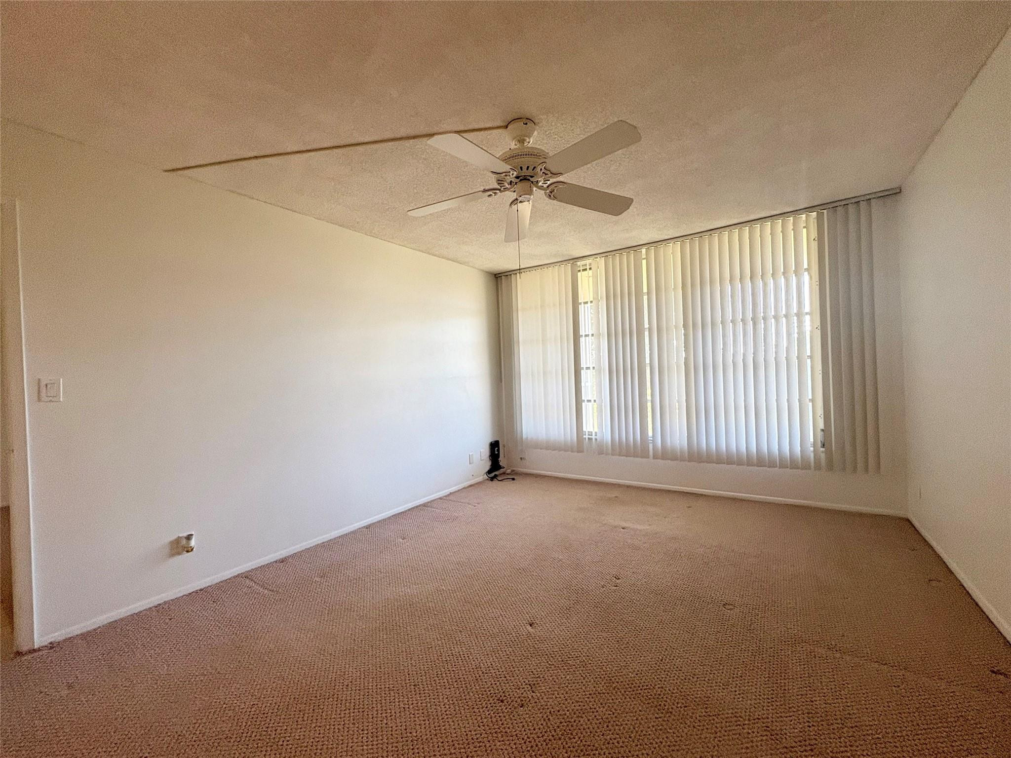 2601 South Course Drive, Unit 406 Pompano Beach, FL 33069 - Photo 6 of 15 an empty room with a empty space and a ceiling fan