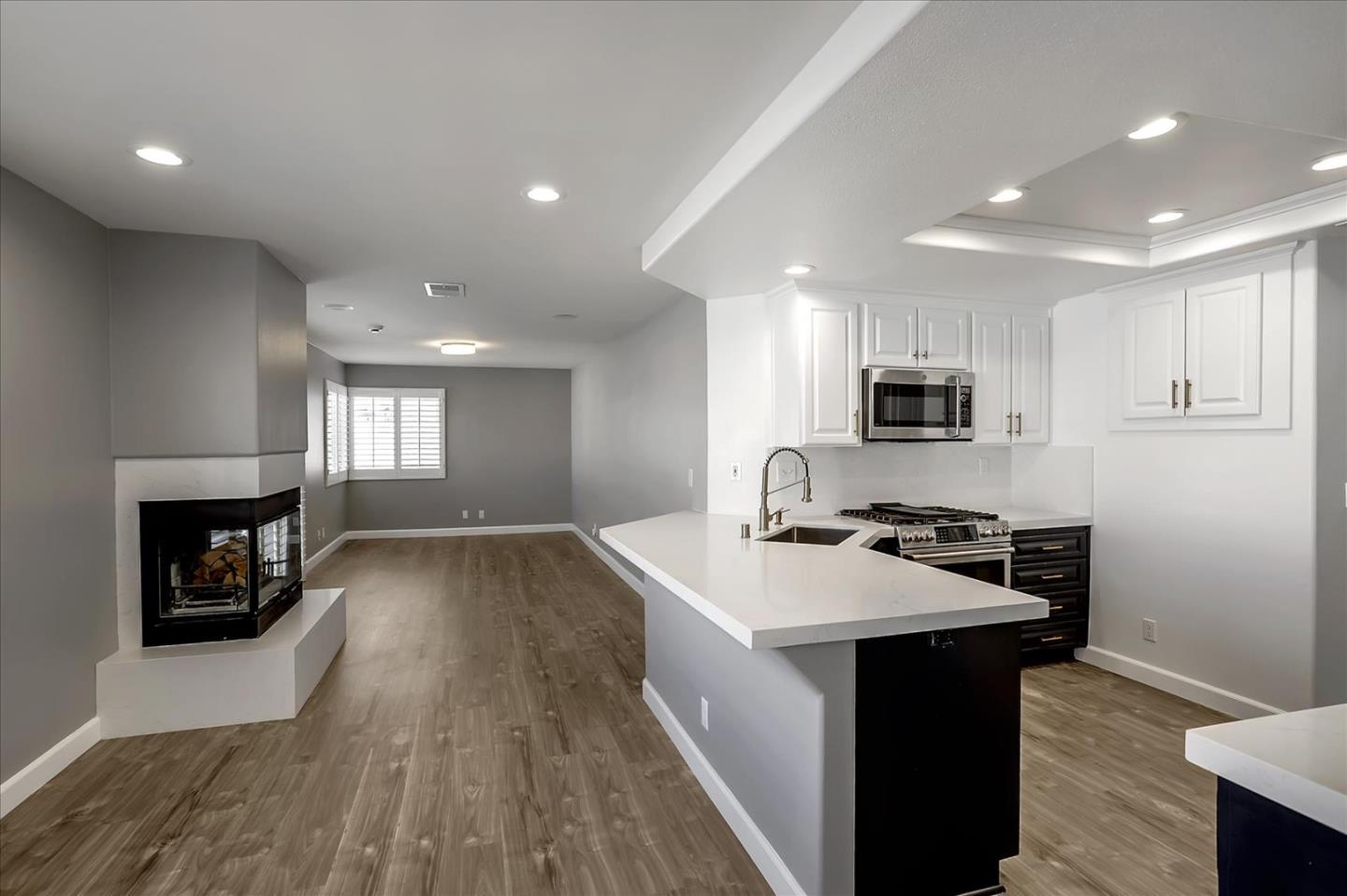 25307 Carson Way Stevenson Ranch, CA 91381 - Photo 12 of 36 a kitchen with stainless steel appliances granite countertop a stove top oven a sink dishwasher and a refrigerator with wooden floor