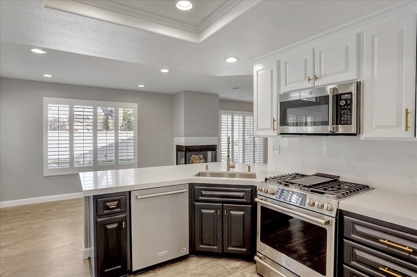 25307 Carson Way Stevenson Ranch, CA 91381 - Photo 14 of 36 a kitchen with stainless steel appliances a stove a microwave and white cabinets