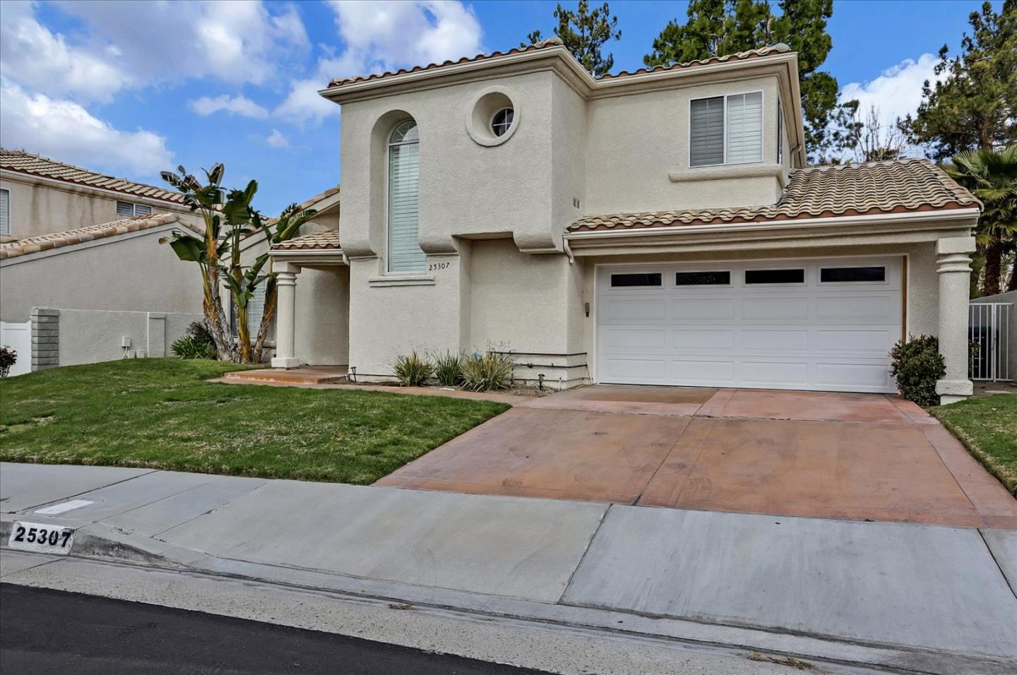 25307 Carson Way Stevenson Ranch, CA 91381 - Photo 3 of 36 a front view of a house with a yard and garage