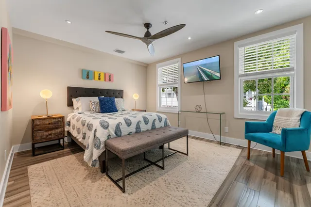 a bedroom with a bed a table and a potted plant