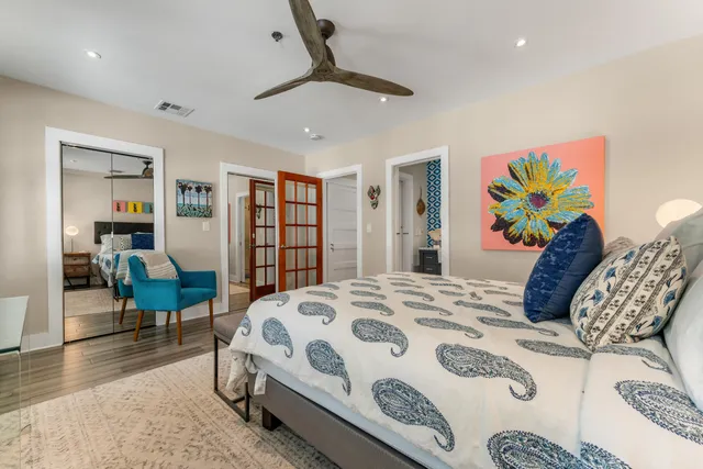 a bedroom with a bed a dresser and a painting on the wall