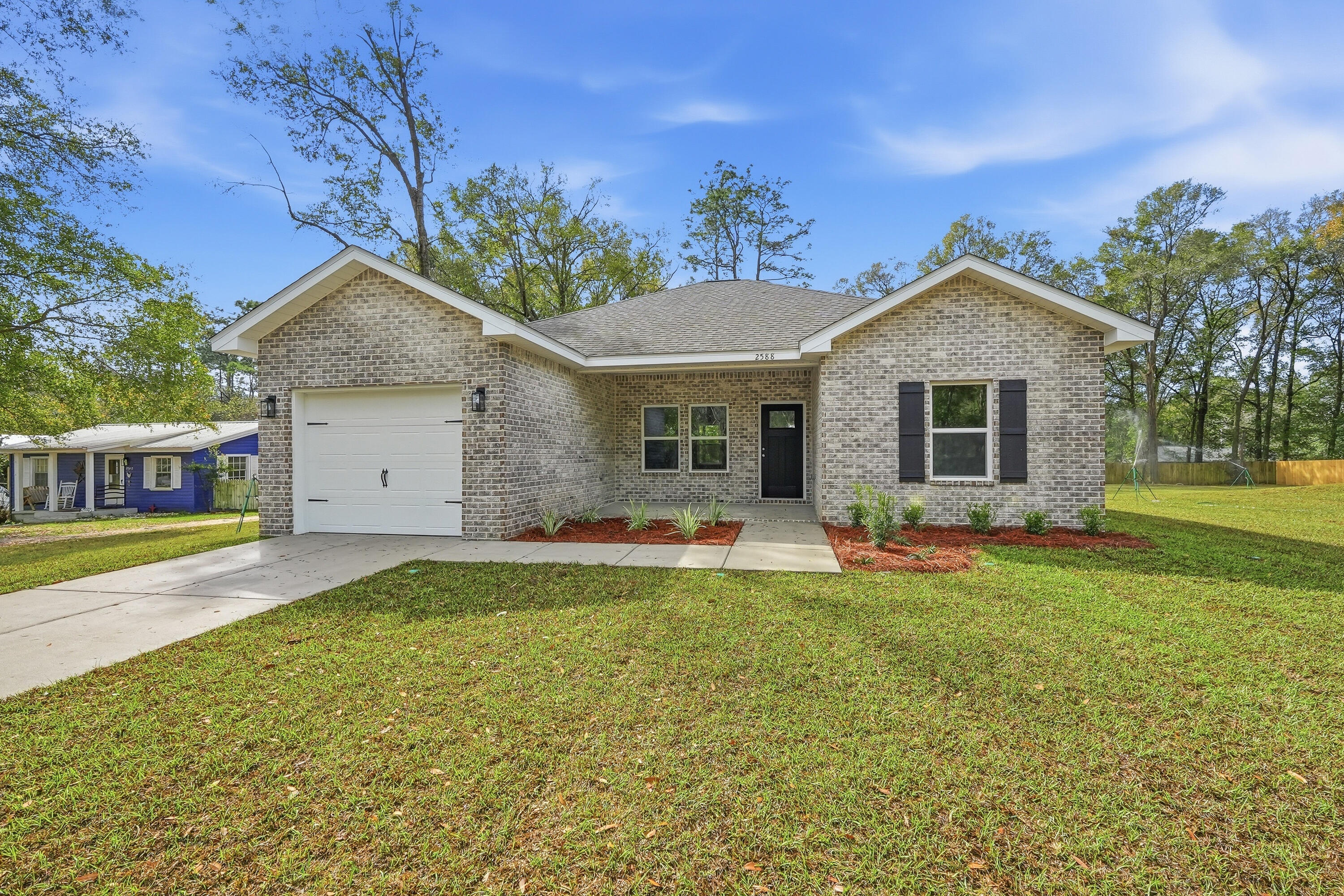 2588 Kingston Road Crestview, FL 32536 - Photo 2 of 23 a front view of a house with a garden and yard