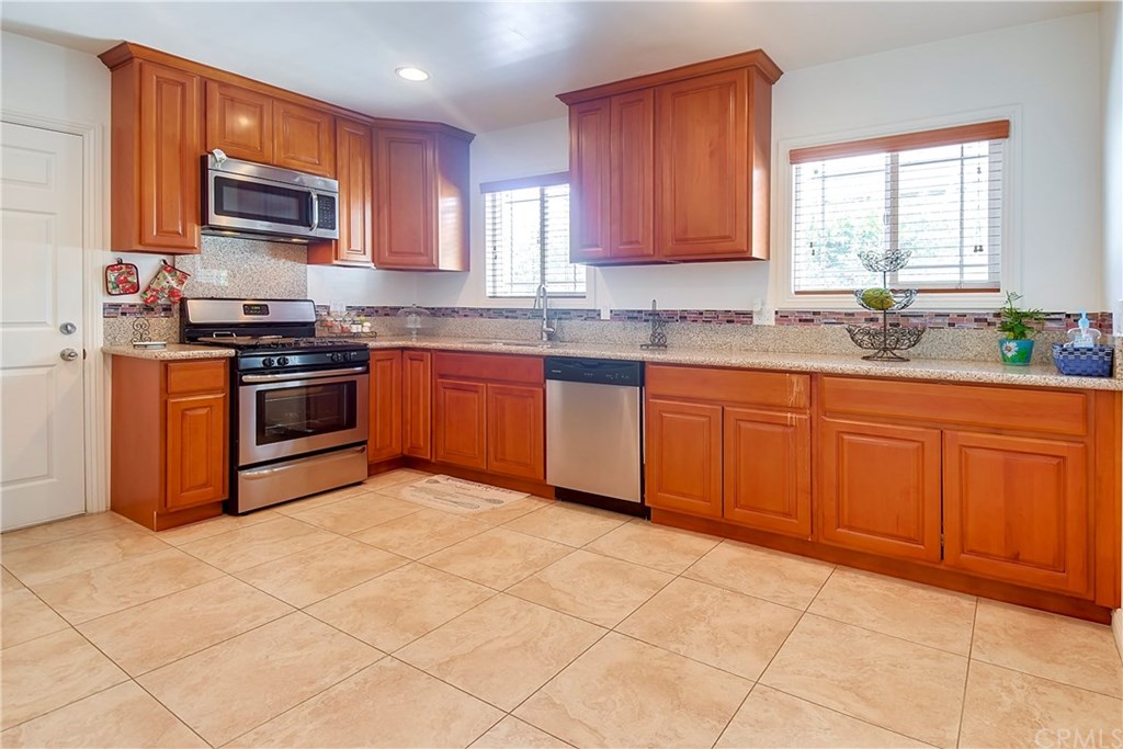 7863 Lyndora Street Downey, CA 90242 - Photo 2 of 27 a kitchen with stainless steel appliances granite countertop a stove sink and microwave