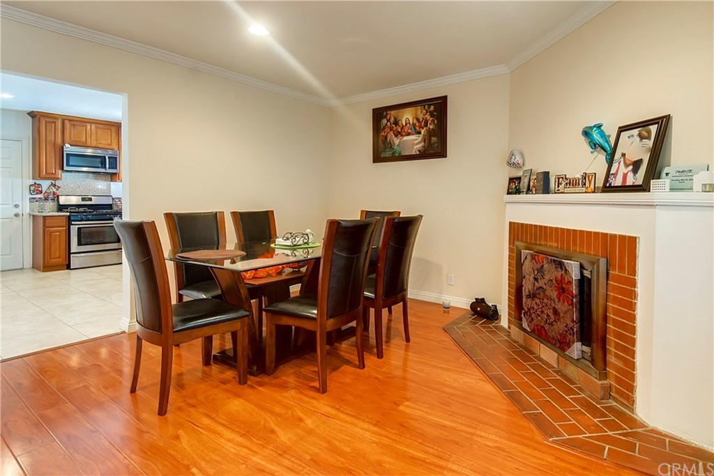 7863 Lyndora Street Downey, CA 90242 - Photo 11 of 27 a view of a dining room with furniture wooden floor and a fireplace
