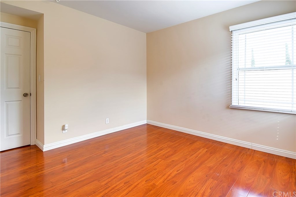 7863 Lyndora Street Downey, CA 90242 - Photo 13 of 27 an empty room with wooden floor and windows