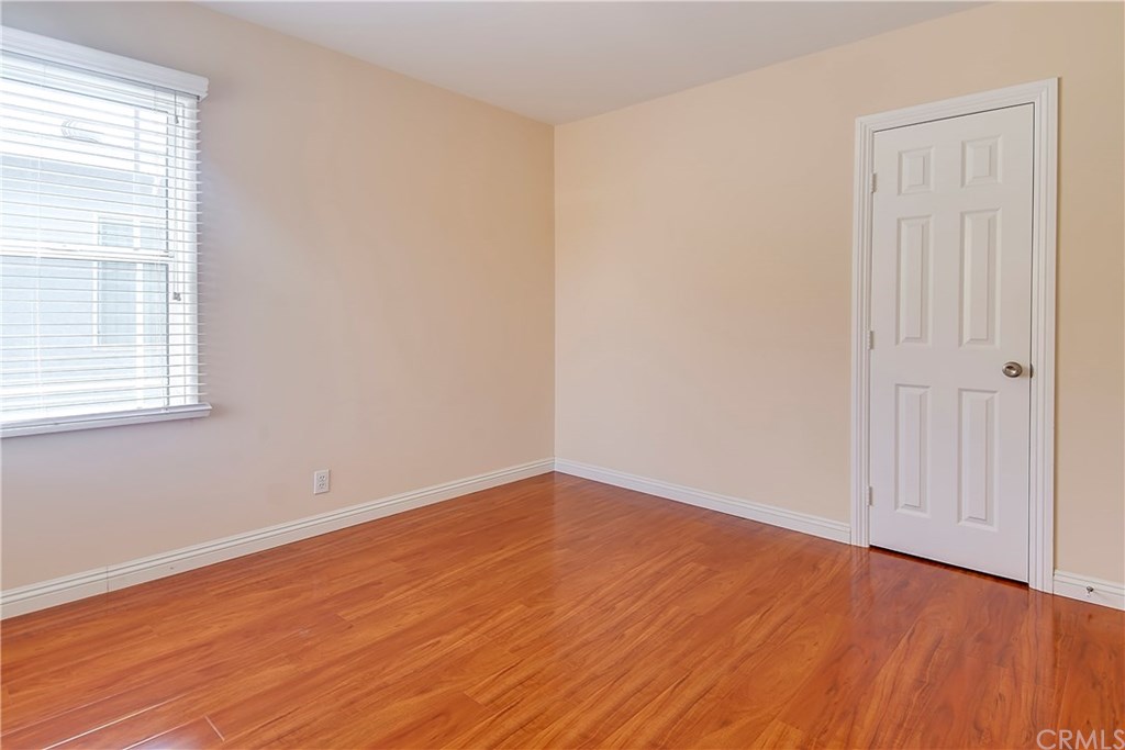 7863 Lyndora Street Downey, CA 90242 - Photo 14 of 27 an empty room with wooden floor and windows