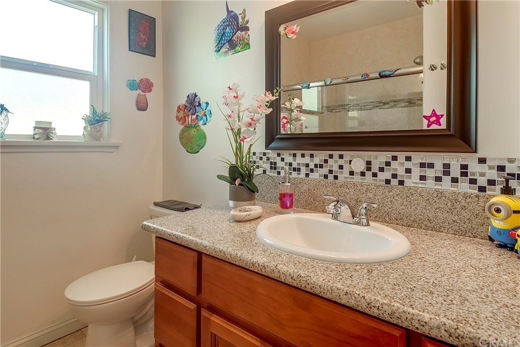7863 Lyndora Street Downey, CA 90242 - Photo 15 of 27 a bathroom with a granite countertop sink and a mirror