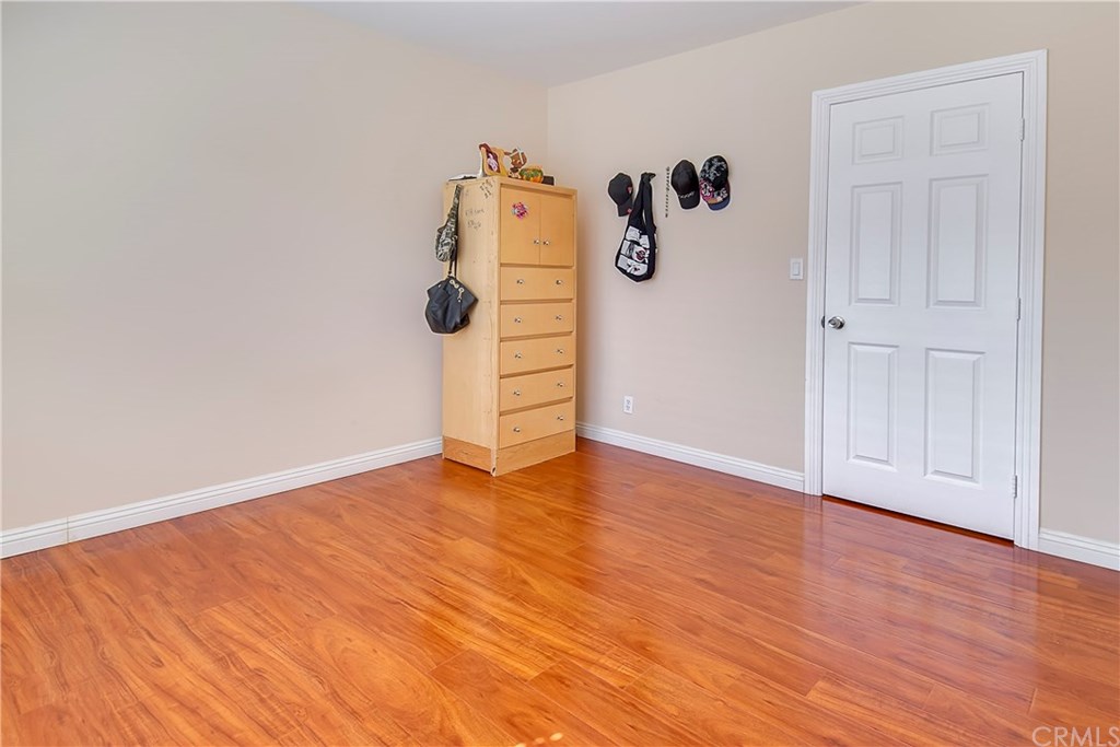 7863 Lyndora Street Downey, CA 90242 - Photo 18 of 27 an empty room with wooden floor and white wall