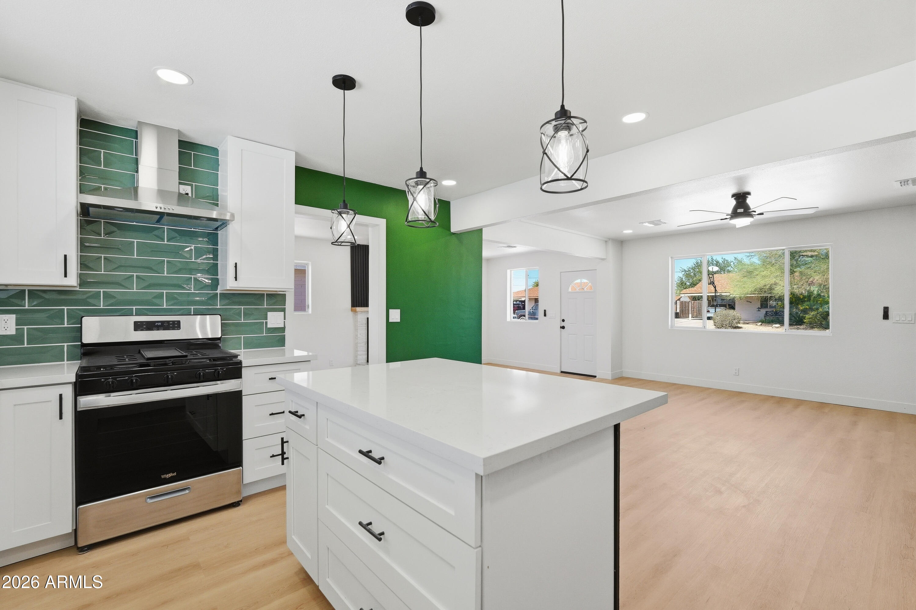 a kitchen with stainless steel appliances granite countertop a stove a refrigerator and a wooden floors