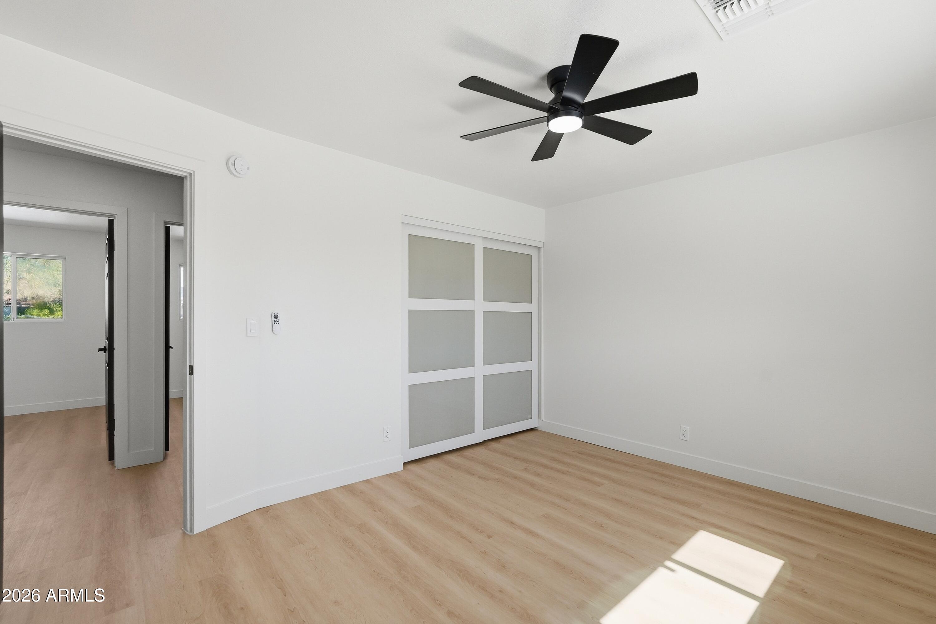 3327 West Wethersfield Road Phoenix, AZ 85029 - Photo 17 of 30 a view of empty room with wooden floor and ceiling fan