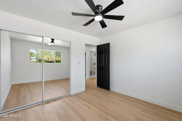 an empty room with windows and ceiling fan