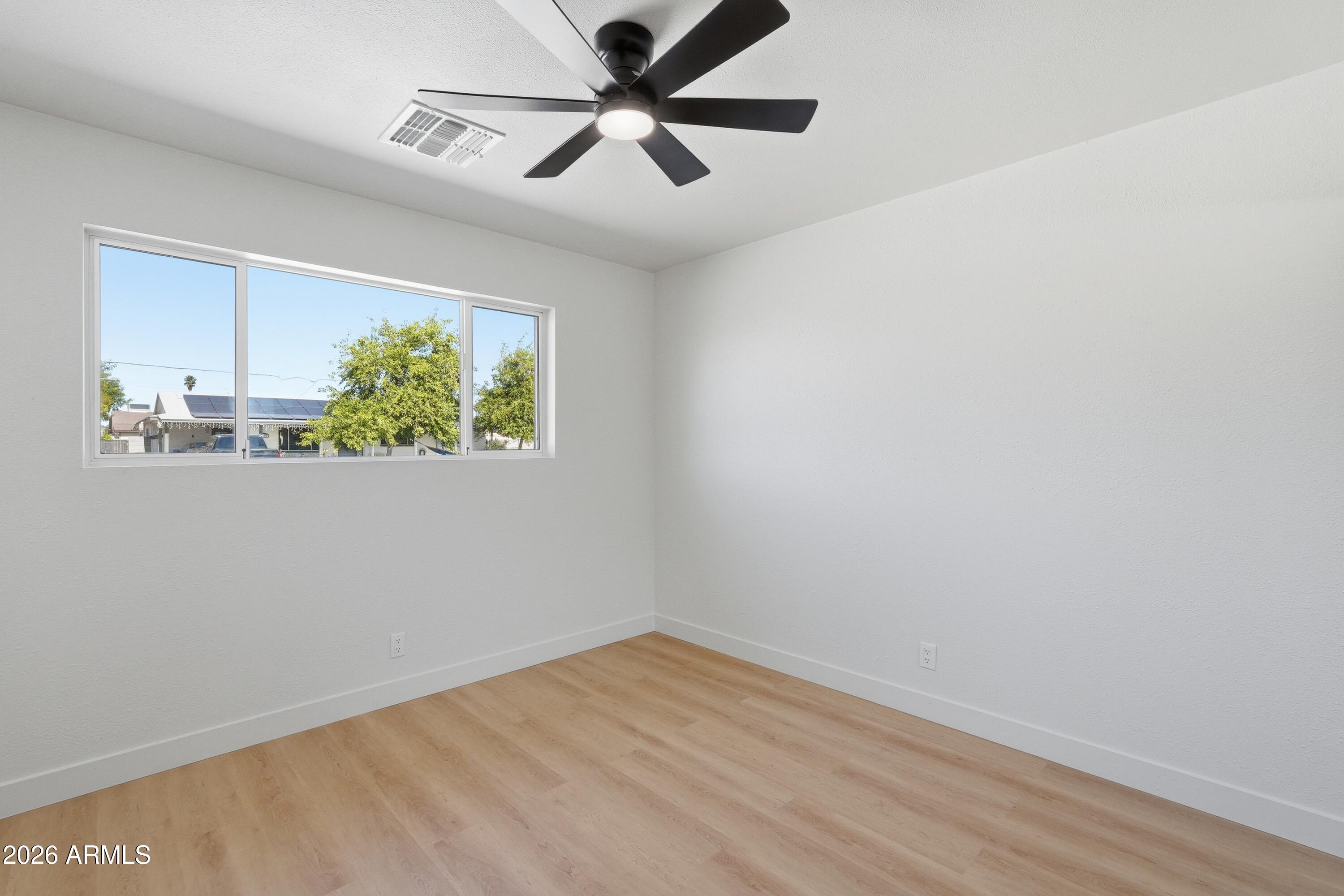 3327 West Wethersfield Road Phoenix, AZ 85029 - Photo 22 of 30 a view of empty room with wooden floor and fan