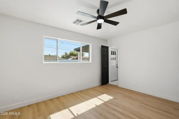 a view of a big room with wooden floor and windows