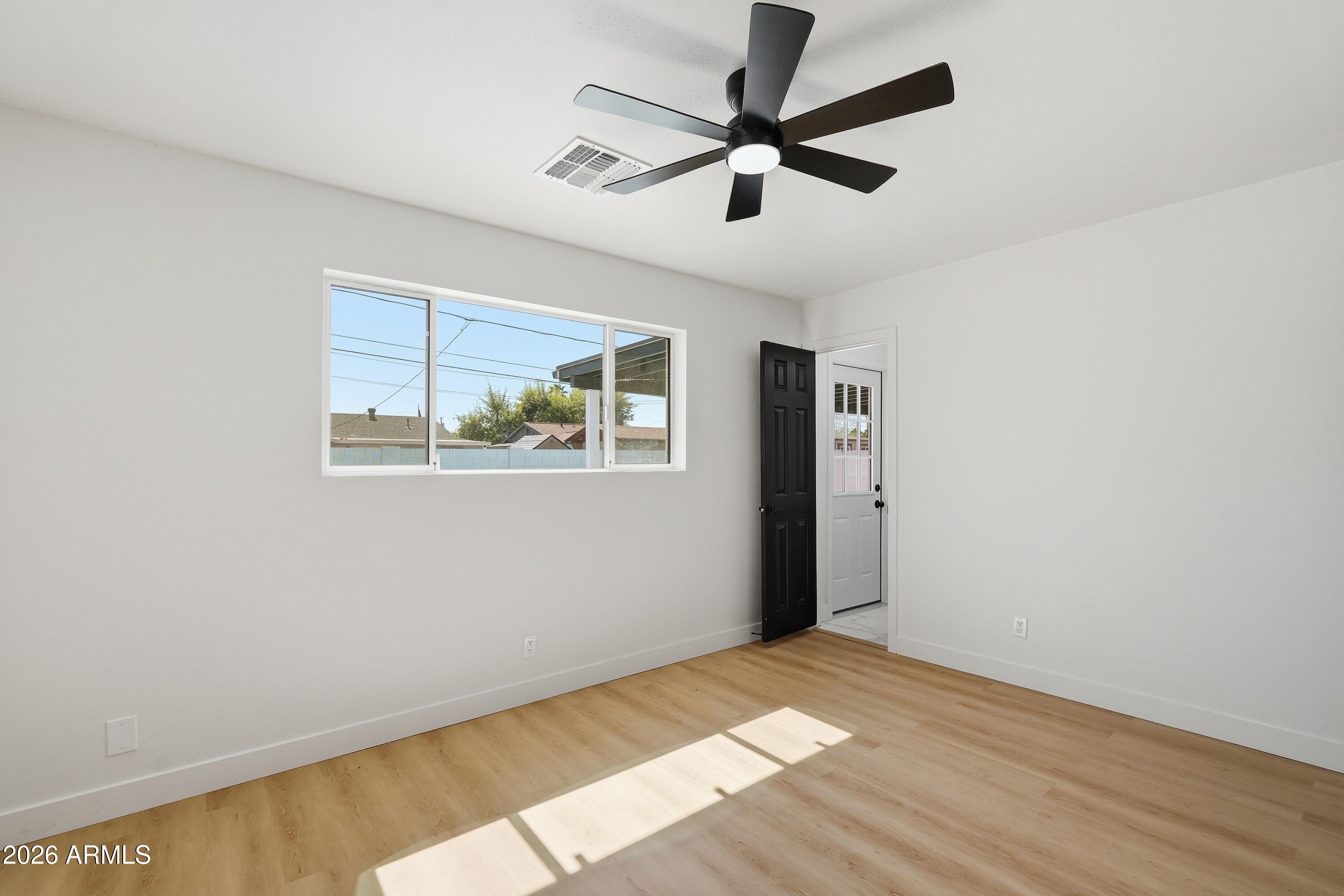 3327 West Wethersfield Road Phoenix, AZ 85029 - Photo 23 of 30 a view of a big room with wooden floor and windows