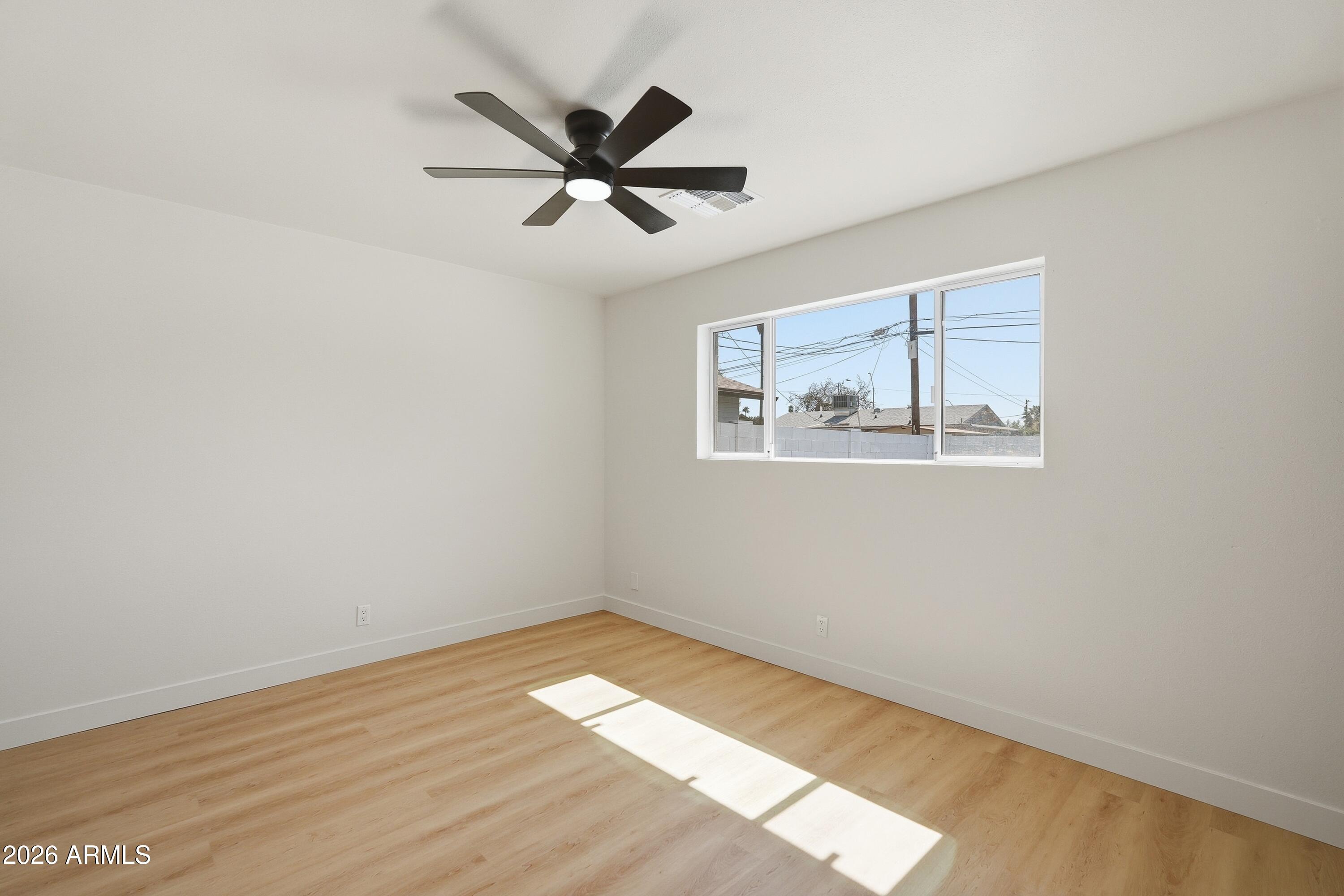 3327 West Wethersfield Road Phoenix, AZ 85029 - Photo 25 of 30 a view of empty room with wooden floor and fan
