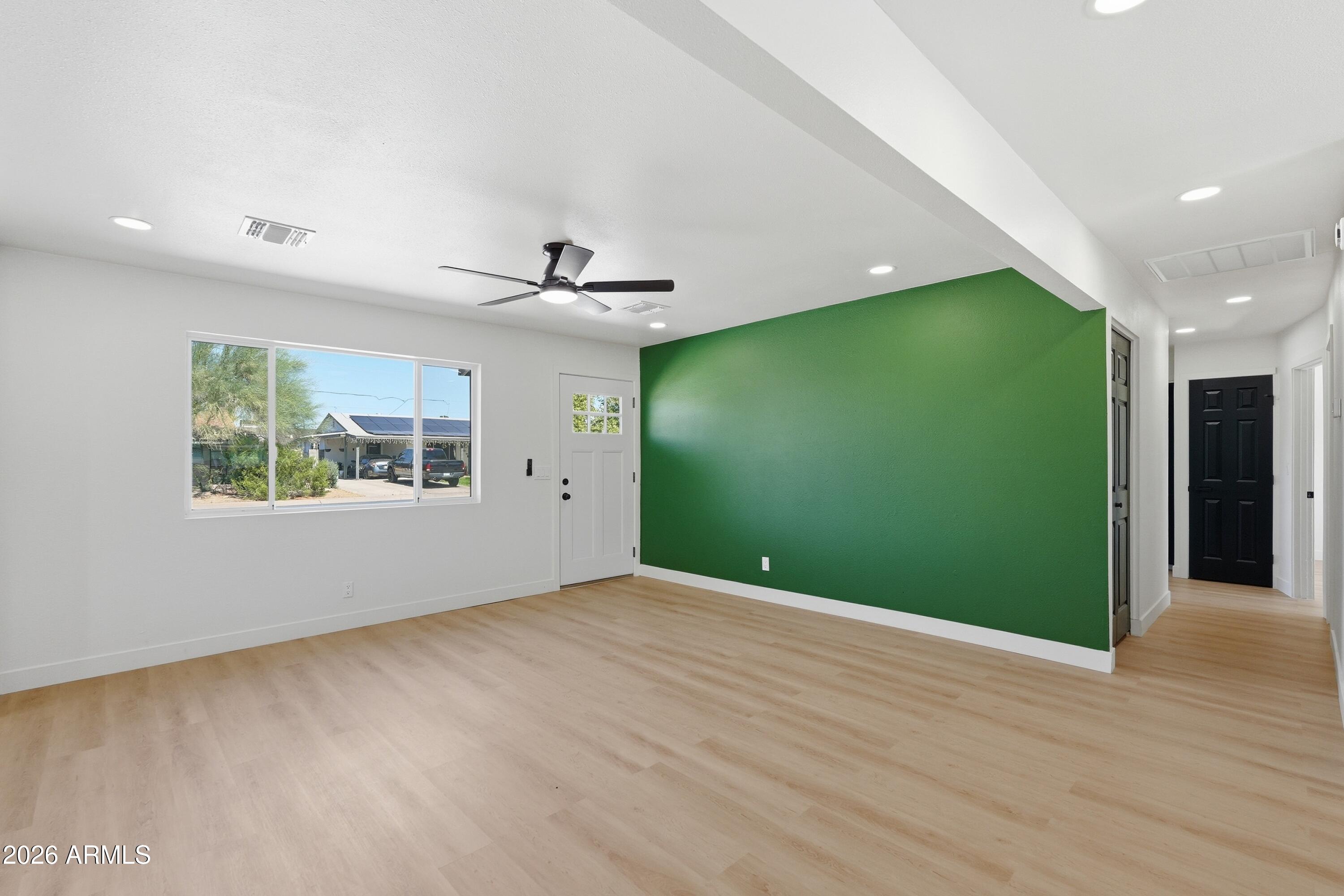 3327 West Wethersfield Road Phoenix, AZ 85029 - Photo 6 of 30 an empty room with wooden floor and windows