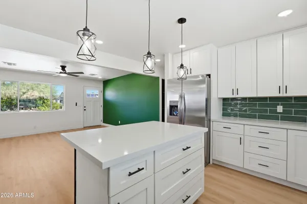 a kitchen with white cabinets and refrigerator