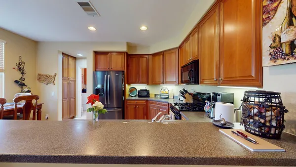 a living room with furniture kitchen view and a wooden floor