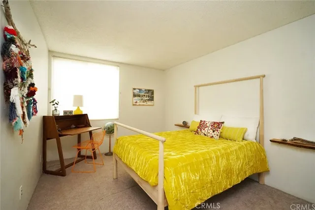 a bed sitting in a bedroom next to a window