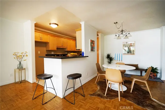 a dining room filled chandelier and kitchen view