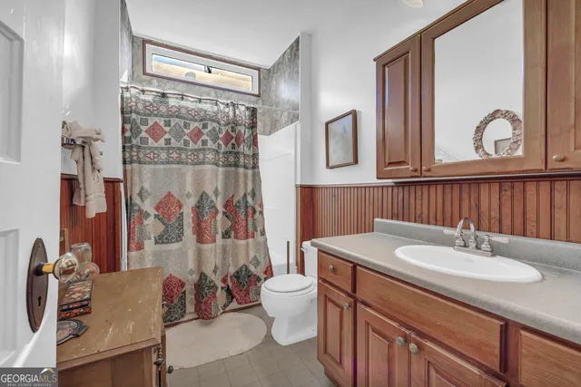 a bedroom with a bed a chair and dresser