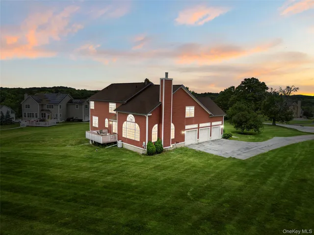 a view of a big house with a big yard and large tree