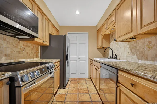 a kitchen with granite countertop a sink and cabinets