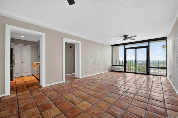 a view of a room with a chandelier fan and wooden floor