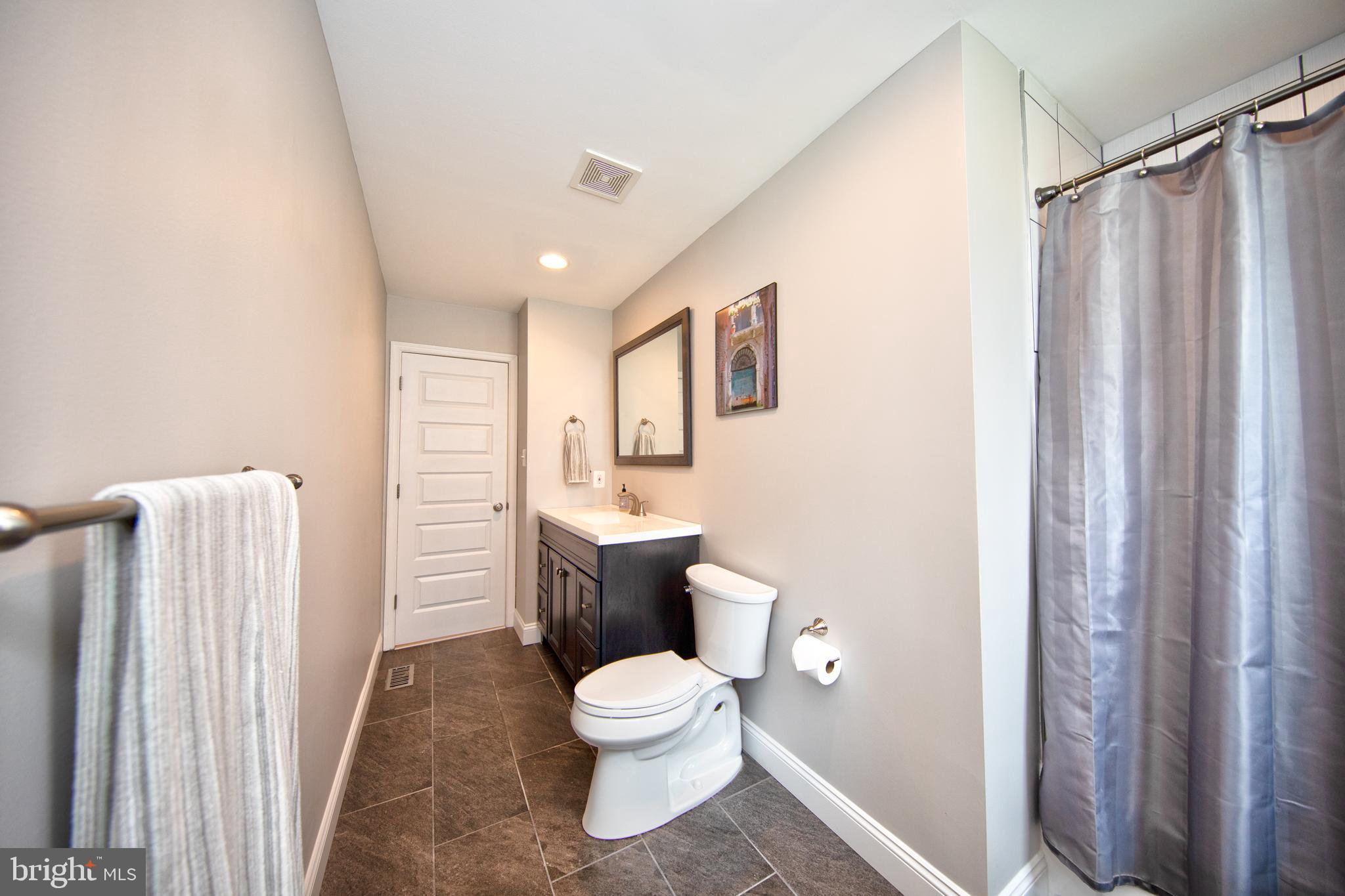 9315 Perglen Road Baltimore, MD 21236 - Photo 18 of 32 a white toilet sitting next to a shower curtain