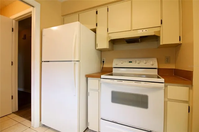 a white refrigerator freezer and a stove sitting inside of a kitchen