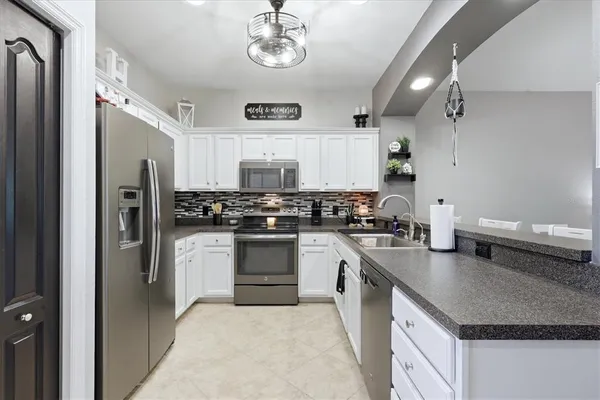 a kitchen with stainless steel appliances granite countertop a refrigerator sink and stove