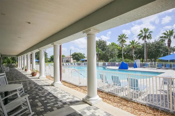 a view of a swimming pool with a patio and a yard