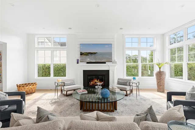 a living room with furniture a large window and a fireplace