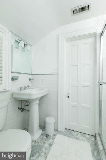1107 Harriton Road Baltimore, MD 21210 - Photo 21 of 30 a bathroom with a sink toilet and shower