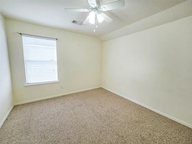 an empty room with a window and a fan
