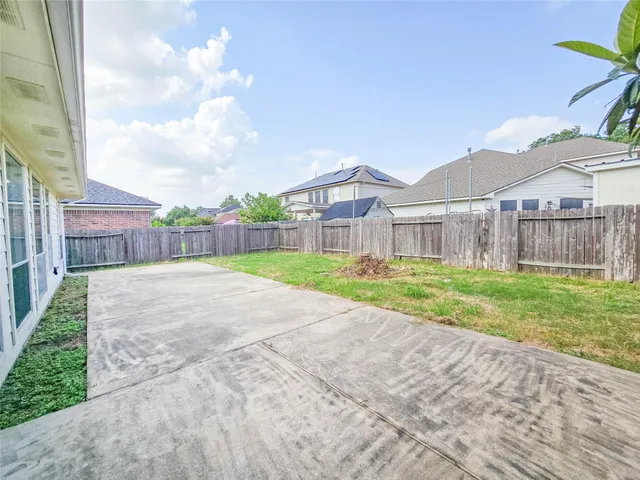 a view of a house with a yard and large tree