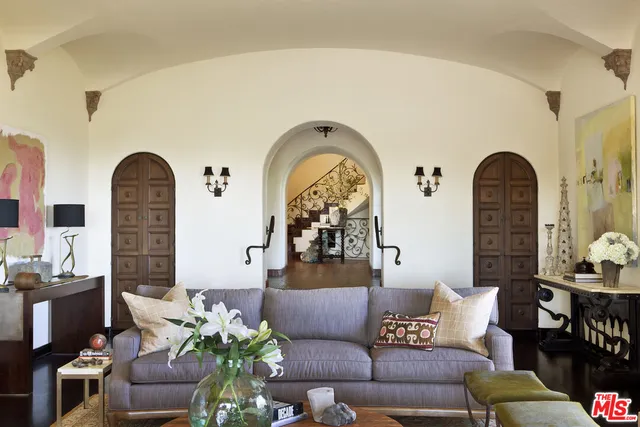 a living room with furniture and potted plants