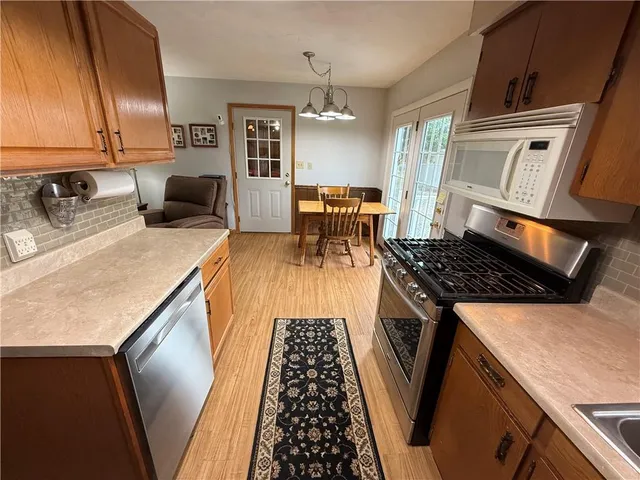 a kitchen with stainless steel appliances granite countertop a stove a sink and a microwave